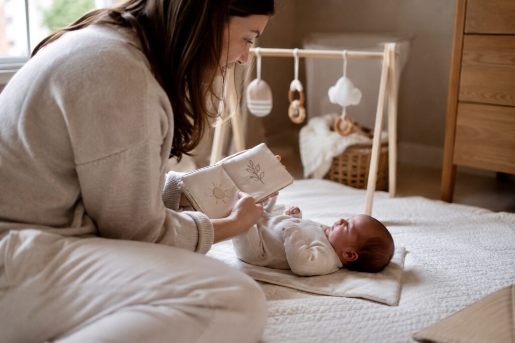 Parent showing crinkle book to newborn during wake window best toys for newborns 
