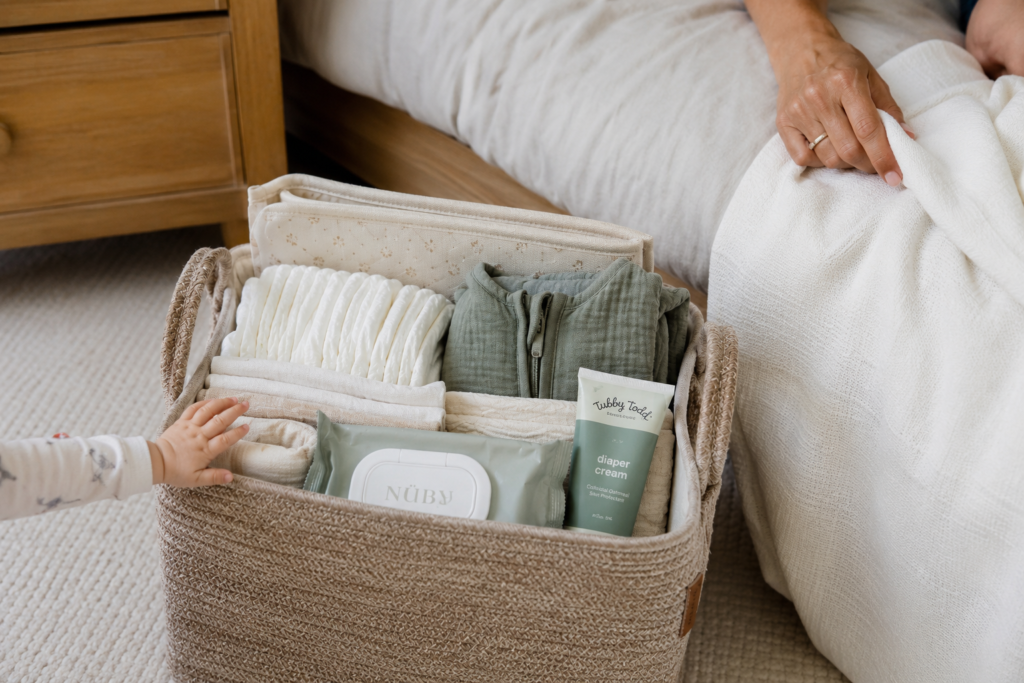 portable diaper caddy beside bed with newborn essentials